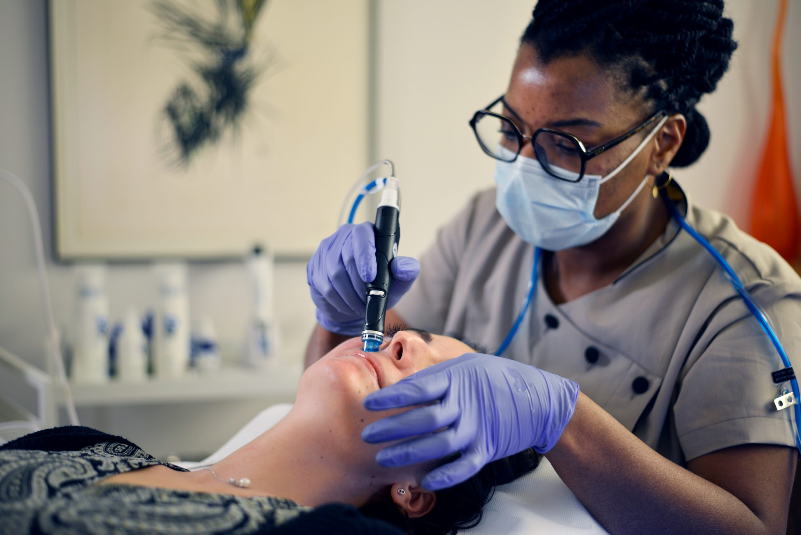 une de nos infirmières esthéticiennes qui pratique un soin hydrafacial paris sur une patiente