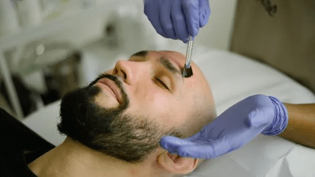 Application d'un peeling sur le visage d'un homme
