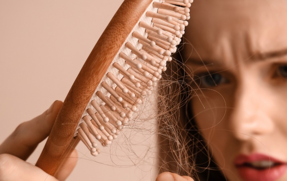 femme qui a sa brosse remplie de cheveux suite à une chute printanière