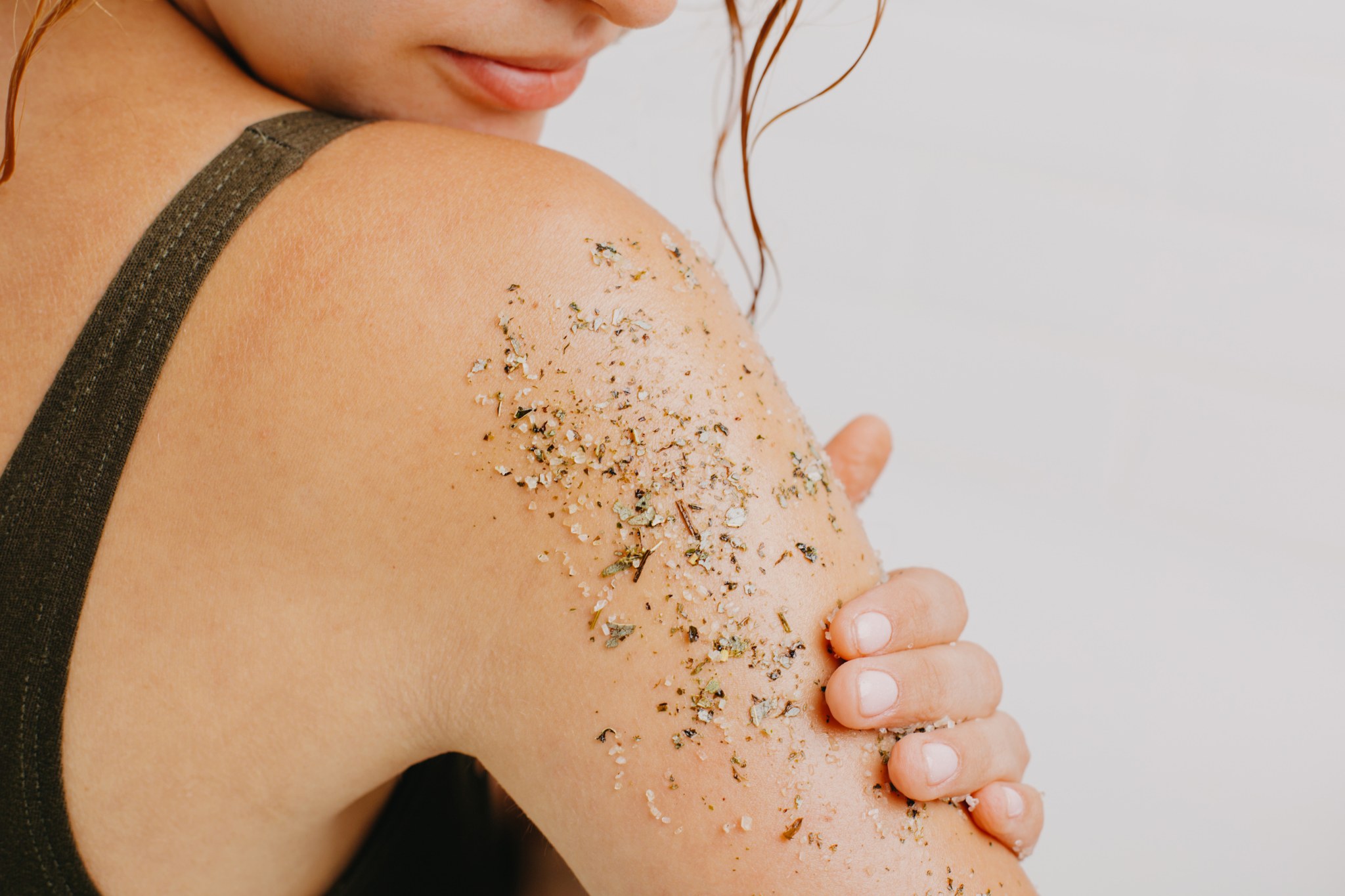 une femme qui se fait un gommage pour illuminer son teint