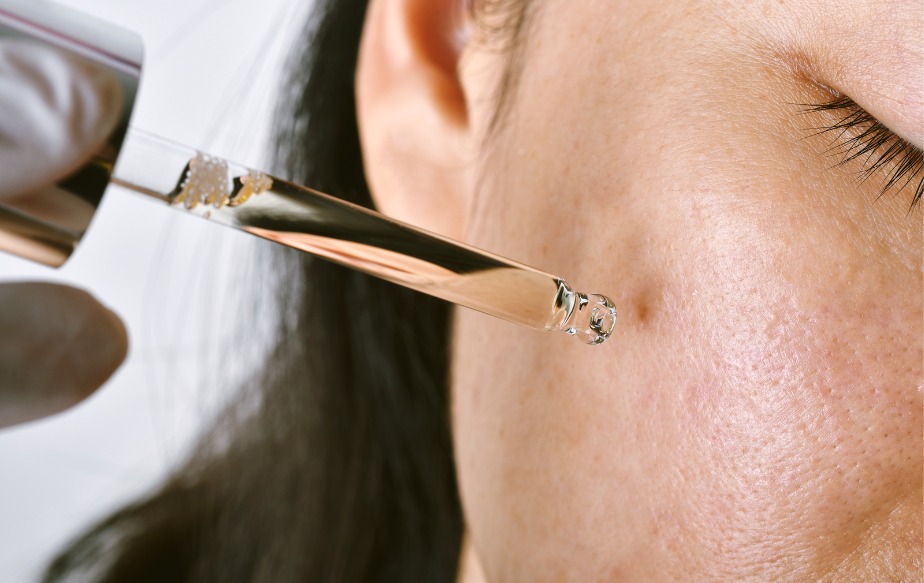 Une personne qui se met de l'huile de tea tree pour calmer son acné